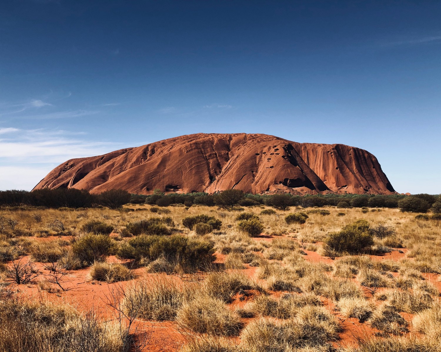 Uluru's iconic orange-red monolith at sunset in the Red Centre