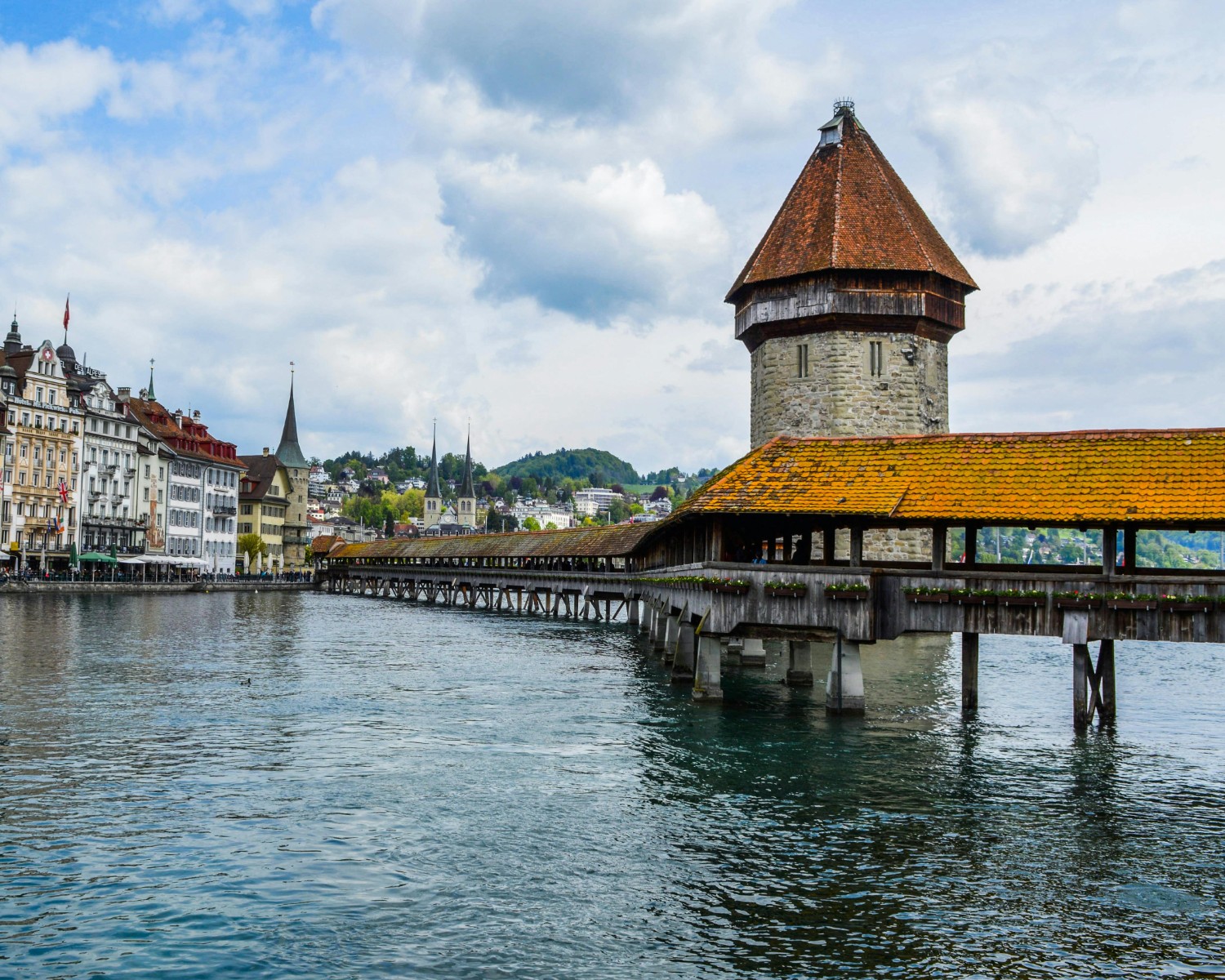 Chapel Bridge in Lucerne with Mount Pilatus rising majestically across serene lake